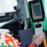 Utente che effettua il pagamento per il bus usando smartphone presso un lettore di biglietti digitale.