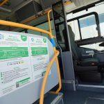 Interno di un autobus con istruzioni per il pagamento contactless del biglietto attraverso smartphone.