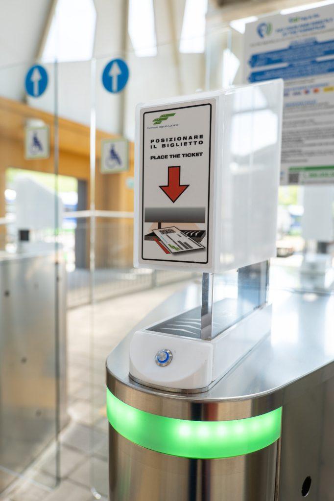 Ticket dispenser at a train station with instructions for users to place their ticket for access.